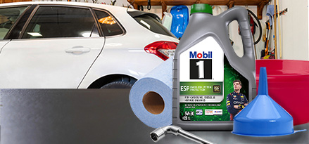 Mobil 1 ESP 5W-30, bir arabanın önünde huni kovası ve kağıt mendil rulosu ile